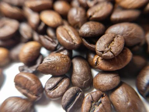A macro image of coffee beans piled together, showcasing their texture and na Stock-Fotos