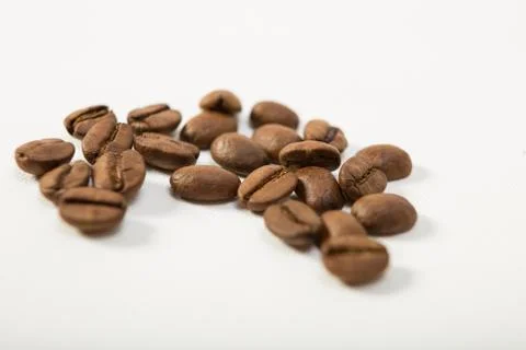 Macro image of dark aromatic coffee beans  on   white background with  copy s Stock Photos
