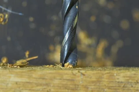 Macro image of the drill bit. Rotating drill bit and flying wood chips. Con.. 写真素材