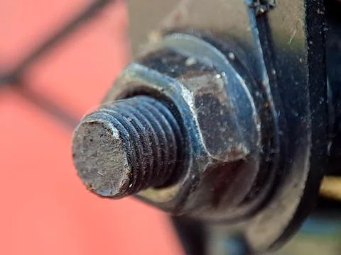 Macro image shows the metal nut secured on a thread; engineering precision .. 库存照片