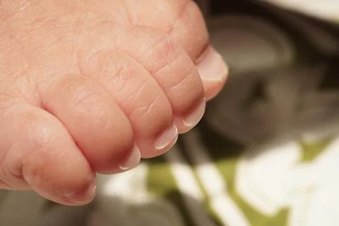 Macro of an infant's tiny nails and delicate wrinkled newborn skin 写真素材