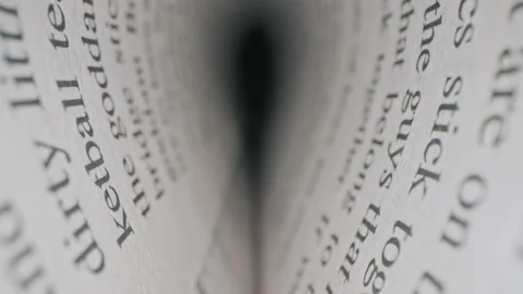 Macro inside book. Camera moves between paper book pages, text in english Stock Footage 144225490