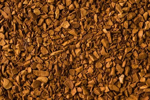 Macro instant coffee granules forming brown textured food background Stock Photos