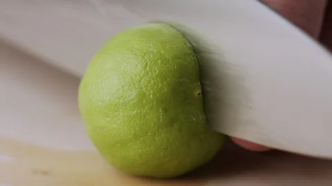 Macro lemon being sliced and dropped slow motion knife lime cutting Stock Footage 274310325