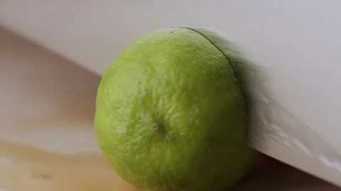 Macro lemon being sliced and dropped slow motion knife lime cutting Stock Footage 274310329