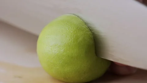 Macro lemon being sliced and dropped slow motion knife lime cutting Stock Footage 274310347
