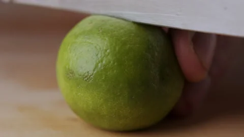 Macro lemon being sliced and dropped slow motion knife lime cutting Stock Footage 274310453