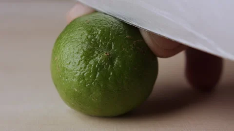 Macro lemon being sliced and dropped slow motion knife lime cutting Stock Footage 274310495
