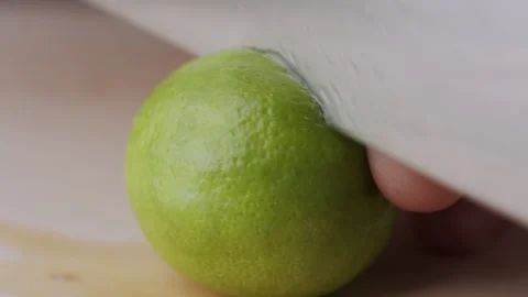 Macro lemon being sliced and dropped slow motion knife lime cutting Stock Footage 274310529