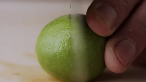 Macro lemon being sliced and dropped slow motion knife lime cutting Stock Footage 274310546