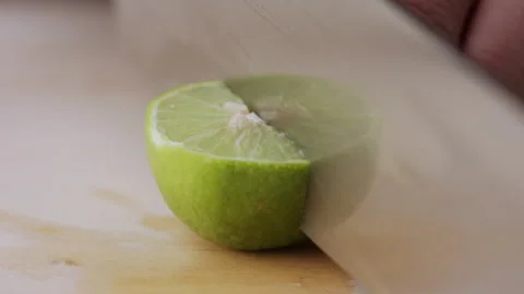 Macro lemon being sliced and dropped slow motion knife lime cutting Stock Footage 274310935