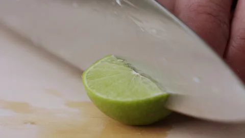 Macro lemon being sliced and dropped slow motion knife lime cutting Stock Footage 274311313
