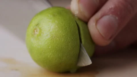 Macro lemon being sliced and dropped slow motion knife lime cutting Stock Footage 274311629