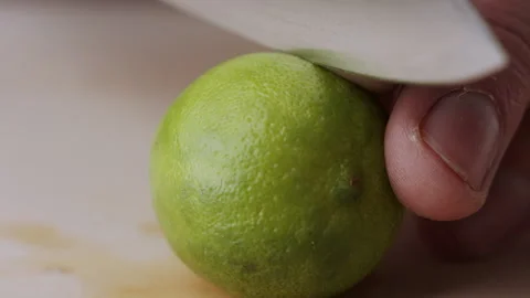 Macro lemon being sliced and dropped slow motion knife lime cutting Stock Footage 274311944