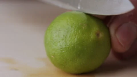 Macro lemon being sliced and dropped slow motion knife lime cutting Stock Footage 274313253