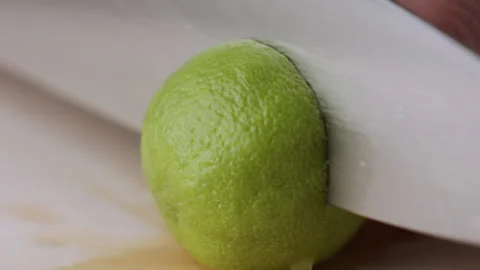 Macro lemon being sliced and dropped slow motion knife lime cutting Stock Footage 274313451