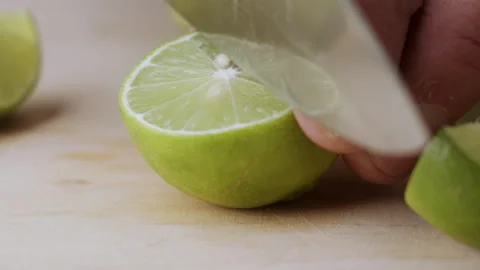 Macro lemon being sliced and dropped slow motion knife lime cutting Stock Footage 274315340
