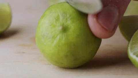 Macro lemon being sliced and dropped slow motion knife lime cutting Stock Footage 274315343