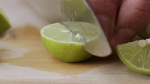Macro lemon being sliced and dropped slow motion knife lime cutting Stock Footage 274315700