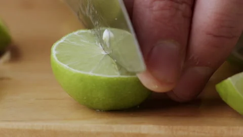 Macro lemon being sliced and dropped slow motion knife lime cutting Vidéo 274315824