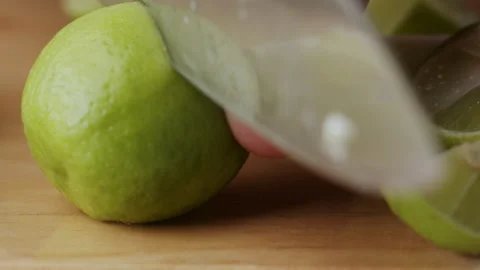 Macro lemon being sliced and dropped slow motion knife lime cutting Stock Footage 274316034