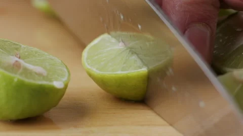 Macro lemon being sliced and dropped slow motion knife lime cutting Stock Footage 274316161