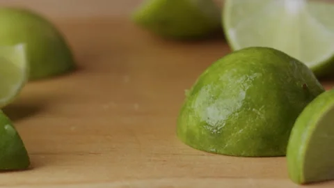 Macro lemon being sliced and dropped slow motion knife lime cutting Stock Footage 274316402