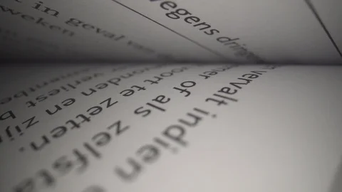 Macro lens sliding trough new book with black phrases and text Stock Footage 124015077