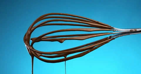 Macro of liquid dark cocoa chocolate cream falls from metal mixing whisk Stock-Footage 268422598