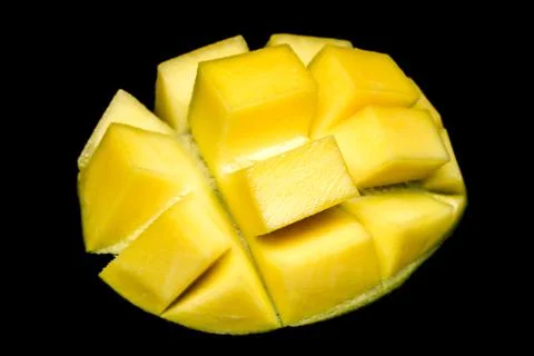 Macro of mango isolated on the black backround. Cubed cut mango. Professional Stock Photos