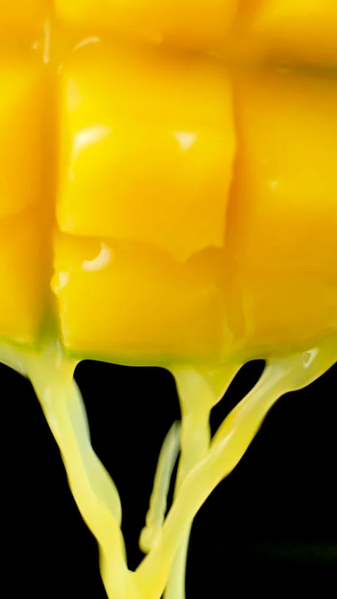 Macro of mango juice dripping from sliced fruit cubes, slow motion Stock Footage 327456794