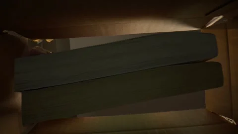 Macro Mans Hand pulling books out a box from underneath Stock Footage 307577129
