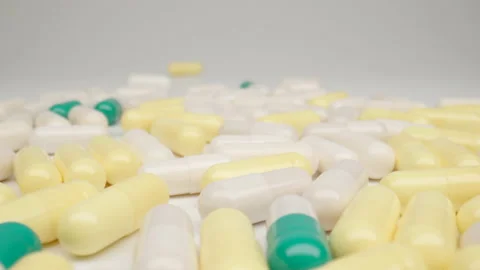 MACRO: Many of capsules on a white table, Dolly shot Видео 165190080