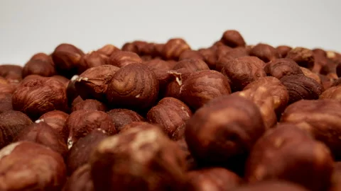 MACRO: Many Peeled hazelnuts on a white background, Dolly shot Stock Footage 165190601