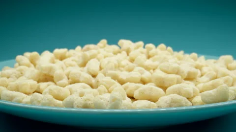 MACRO: Many star figure corn flackes on a blue dish, Dolly motion Видео 154980195