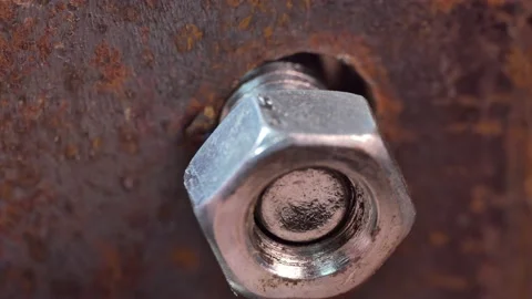 Macro. The master inserts the bolt into the hole and tightens the nut. Stock-Footage 151438032