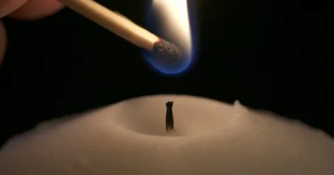 Macro of a match lighting a candle Stock Footage 74350056