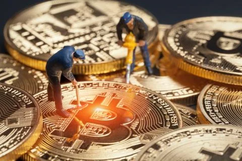 Macro miner figures working on group of bitcoins. virtual cryptocurrency mini Stock Photos
