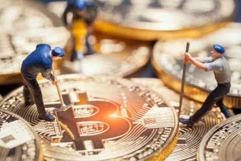 Macro miner figures working on group of bitcoins. virtual cryptocurrency mini Stock-Fotos