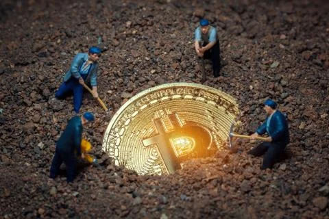 Macro miner figurines digging ground to uncover big shiny bitcoin Stock Photos