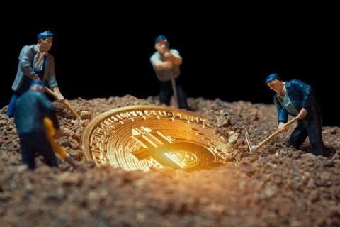 Macro miner figurines digging ground to uncover big shiny bitcoin Stock-Fotos