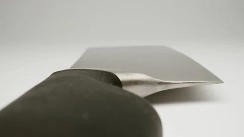 MACRO: Motion over big kitchen knife on a white background, Dolly shot Stock-Footage 165189541
