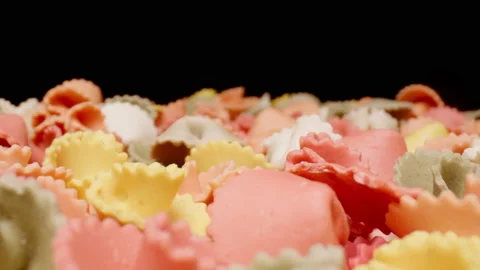 MACRO: Motion over colourful figural pasta on a black background Stock Footage 144417482