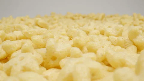 MACRO: Motion over corn flakes (star figure) on a white background, Dolly shot Stock-Footage 165190354