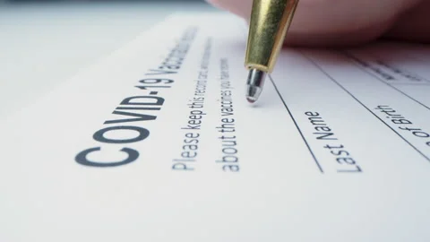 Macro moving shot of issuing Covid-19 vaccination record card Stock Footage 149019135