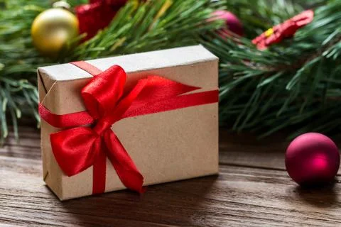 Macro of nice Christmas gift box decorated with red silk stripe, on the blurred Stock Photos