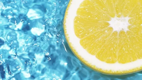 Macro orange fruit slice and blue water surface texture with ripples and splash Stock Footage 166192303