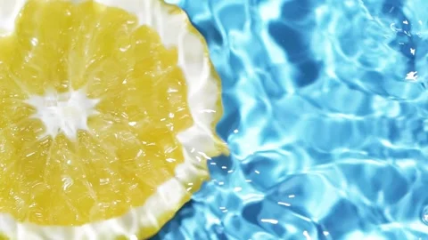 Macro orange fruit slice and blue water surface texture with ripples and splash Video stock 169331767