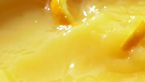 Macro orange fruit slice falling down into fresh orange juice drink, slow motion Stock Footage 142558286