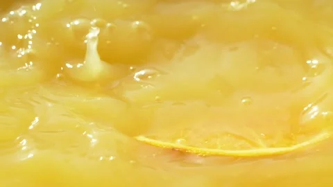 Macro orange fruit slice falling down into fresh orange juice drink, slow motion Stock Footage 143449657